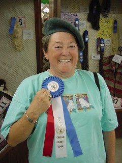 Woman showing fair ribbon and wearing the felted hat