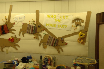Display board with hogs and theme of fair, who let the hogs out