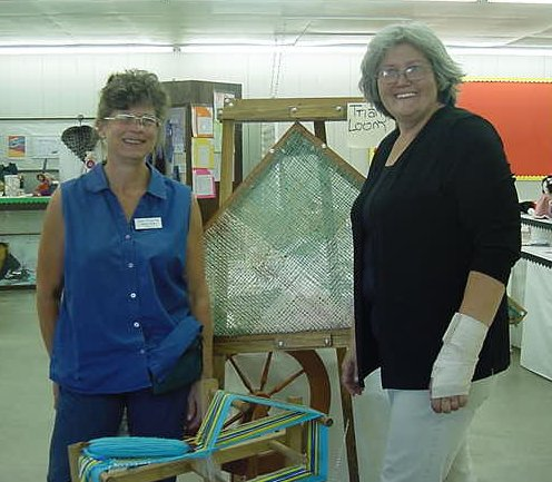 Fair managers posing in front of triangle loom