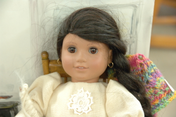 Doll in handwoven blouse with crochet flower and handspun, knitted shawl.