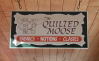 Sign hanging from ceiling, Quilted Moose.