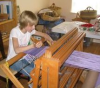 Girl weaving on Baby Wolf loom.