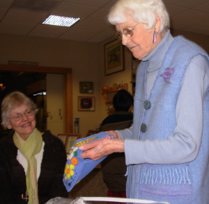 Woman holding up felted purse.